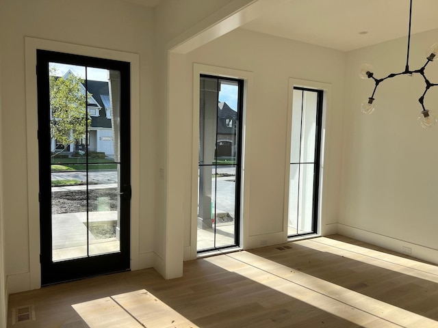 doorway with visible vents and wood finished floors