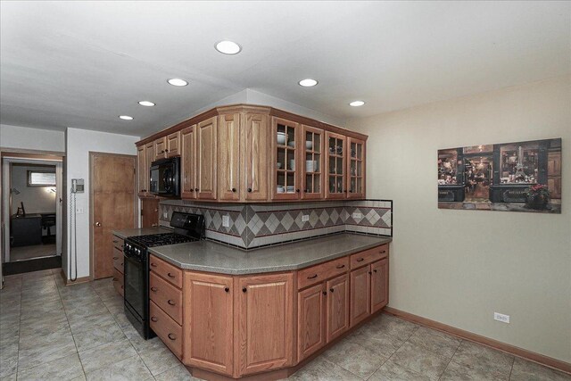 kitchen with recessed lighting, glass insert cabinets, tasteful backsplash, black appliances, and dark countertops