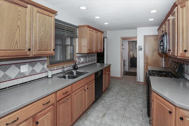 kitchen with a sink, baseboards, black appliances, recessed lighting, and backsplash