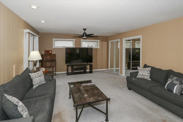 carpeted living room with ceiling fan and baseboards