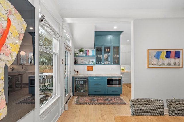 1942 Orrington Ave, Evanston, IL 60201 - bar featuring beverage cooler, stainless steel microwave, indoor wet bar, backsplash, and light wood finished floors