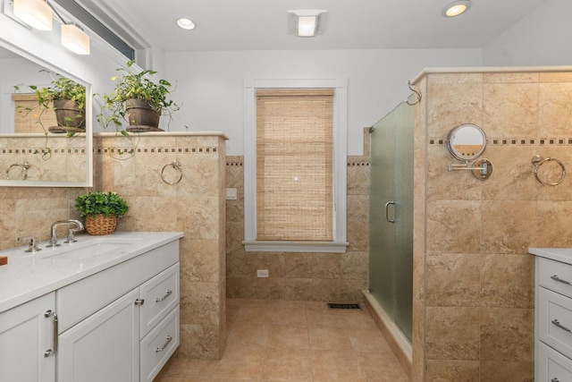 1942 Orrington Ave, Evanston, IL 60201 - full bathroom with tile walls, vanity, a stall shower, visible vents, and tile patterned flooring
