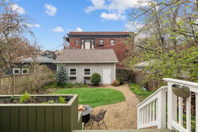1942 Orrington Ave, Evanston, IL 60201 - back of house featuring a fenced backyard, a yard, a fire pit, a patio area, and roof with shingles