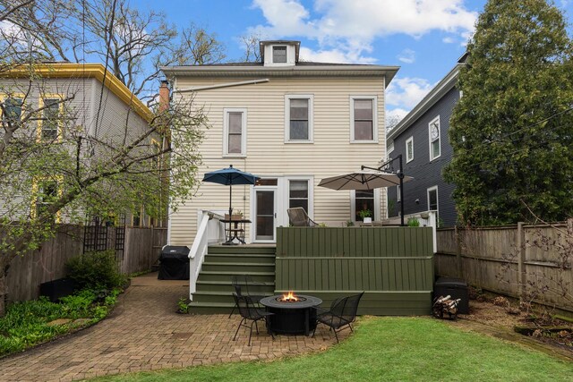1942 Orrington Ave, Evanston, IL 60201 - rear view of property with a patio area, a fenced backyard, a lawn, a deck, and a fire pit