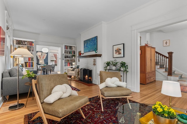1942 Orrington Ave, Evanston, IL 60201 - living room featuring stairway, wood finished floors, built in shelves, and a brick fireplace