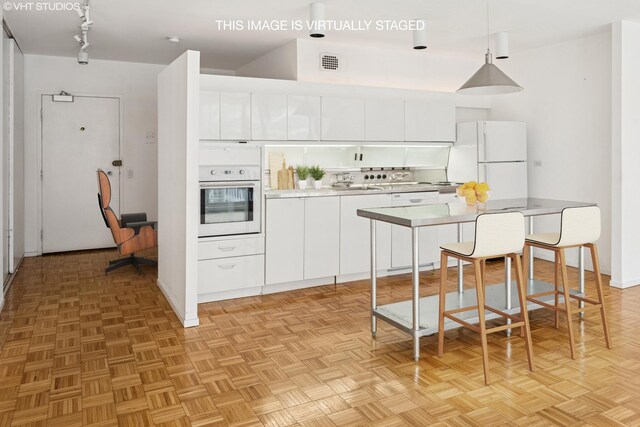 880 N Lake Shore Dr Unit 6G, Chicago, IL 60611 - kitchen featuring white appliances, white cabinetry, light countertops, hanging light fixtures, and track lighting