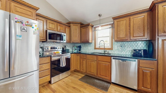 2220 Manico Dr, Crest Hill, IL 60403 - kitchen featuring stainless steel appliances, dark countertops, lofted ceiling, light wood-style floors, and brown cabinetry