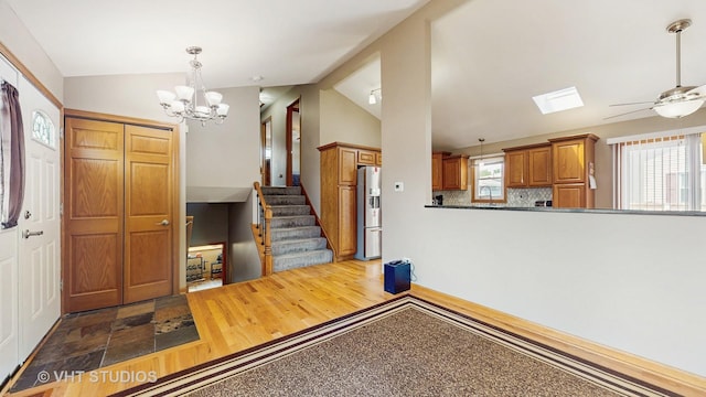2220 Manico Dr, Crest Hill, IL 60403 - entryway with lofted ceiling, a chandelier, a ceiling fan, stairway, and a skylight