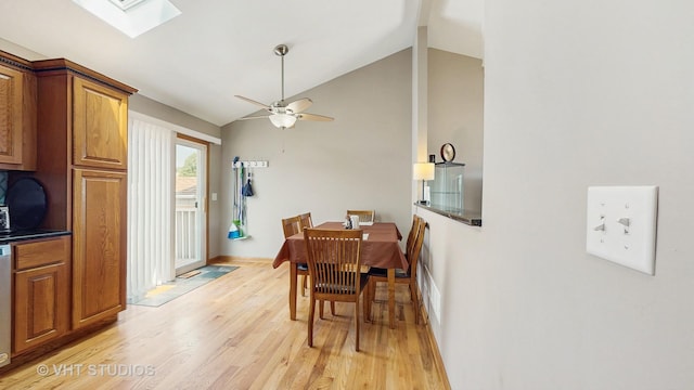2220 Manico Dr, Crest Hill, IL 60403 - dining room featuring light wood-style floors, vaulted ceiling, a skylight, and a ceiling fan