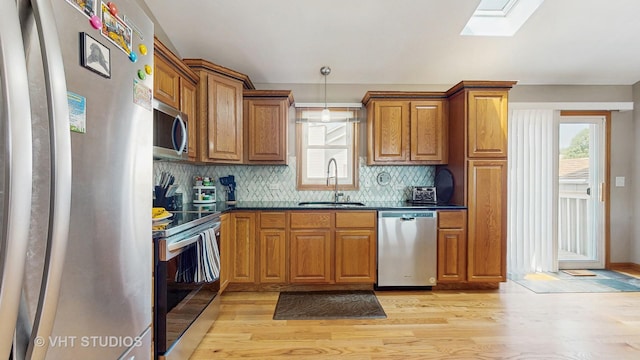 2220 Manico Dr, Crest Hill, IL 60403 - kitchen with appliances with stainless steel finishes, brown cabinets, a skylight, and light wood-type flooring