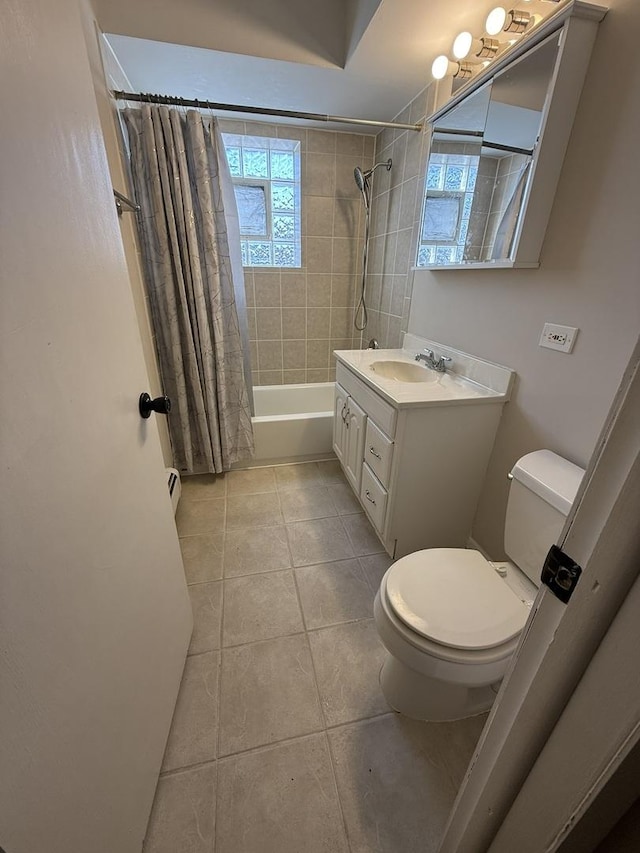 bathroom with tile patterned floors, shower / bath combo with shower curtain, vanity, and toilet
