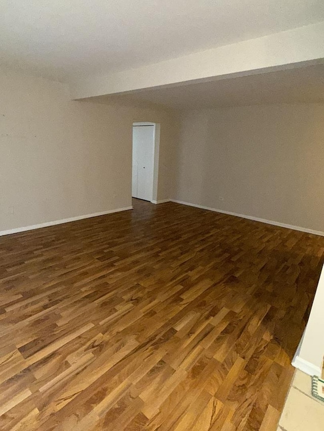 spare room featuring baseboards and wood finished floors