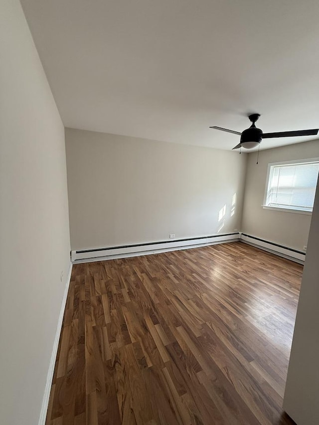 unfurnished room with a baseboard radiator, dark wood finished floors, a ceiling fan, and baseboards