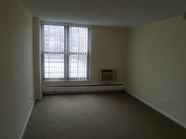 5401 S Hyde Park Blvd Unit 705, Chicago, IL 60615 - spare room featuring a baseboard radiator, a wealth of natural light, carpet flooring, and baseboards