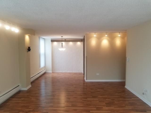 5401 S Hyde Park Blvd Unit 705, Chicago, IL 60615 - empty room with a baseboard radiator, wood finished floors, and a textured ceiling