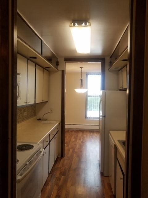5401 S Hyde Park Blvd Unit 705, Chicago, IL 60615 - kitchen with a baseboard heating unit, white appliances, light countertops, white cabinets, and dark wood-style floors