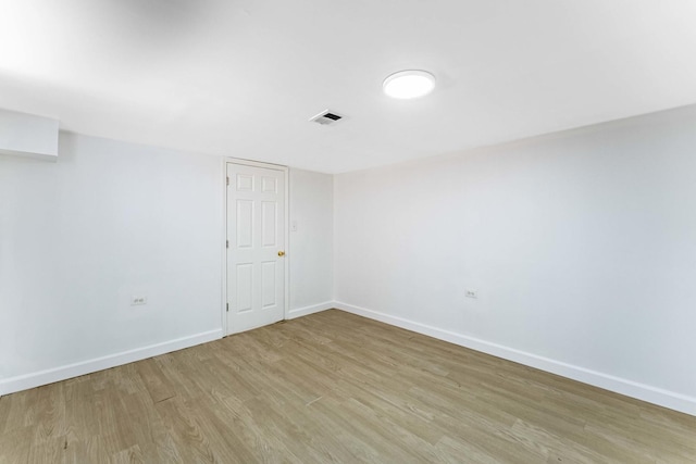 spare room with baseboards, visible vents, and light wood-type flooring