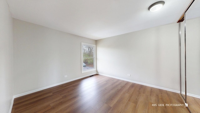 unfurnished room featuring wood finished floors and baseboards
