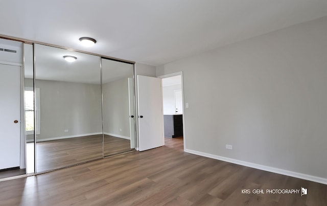 unfurnished bedroom with wood finished floors and baseboards