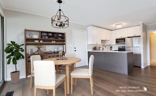 dining room with crown molding, a chandelier, dark wood finished floors, and baseboards