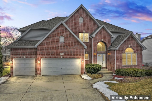 traditional home with brick siding, driveway, roof with shingles, and a garage
