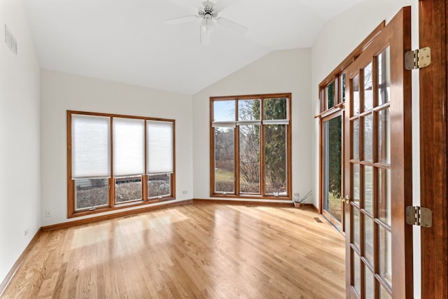 unfurnished room featuring vaulted ceiling, wood finished floors, a ceiling fan, and baseboards