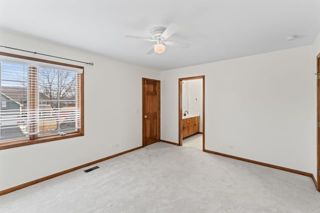 empty room featuring a ceiling fan, baseboards, and light colored carpet