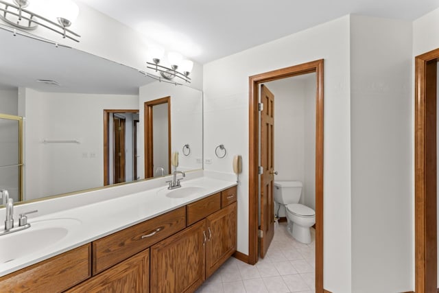 full bathroom featuring toilet, tile patterned floors, a sink, and double vanity