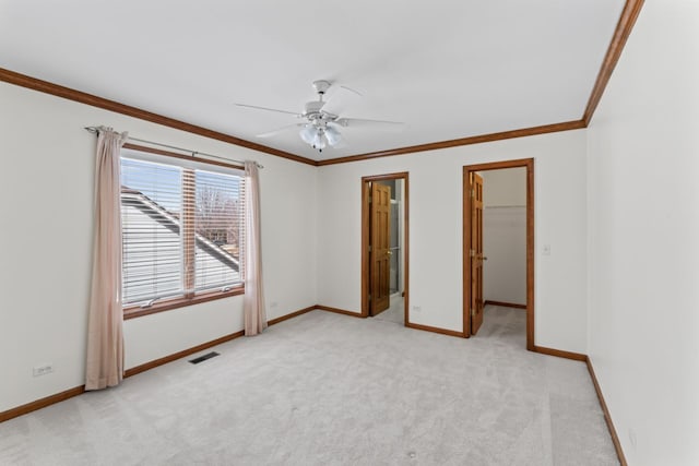 spare room with light colored carpet, baseboards, and crown molding