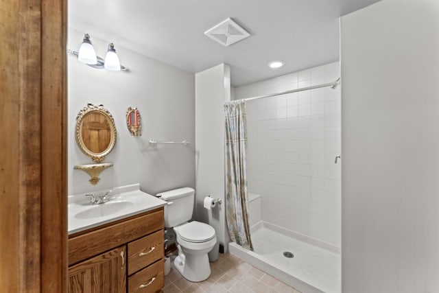 bathroom with a tile shower, toilet, vanity, and tile patterned floors