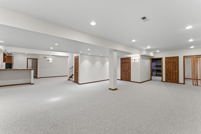 finished below grade area featuring stairway, visible vents, and recessed lighting