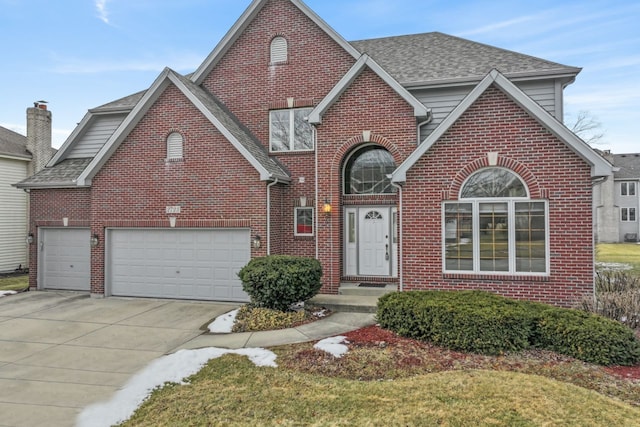 traditional-style house with brick siding, an attached garage, driveway, and a shingled roof