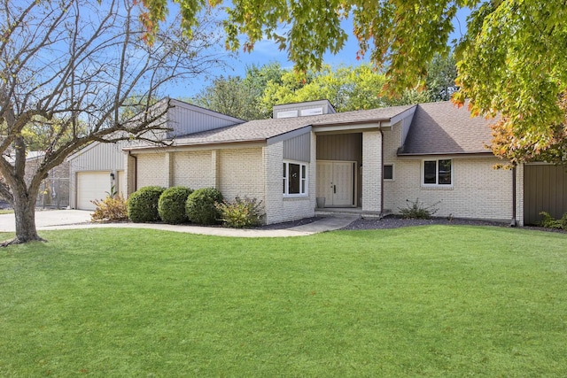 2104 Oakwood Ave, Bloomington, IL 61704 - mid-century modern home featuring a front yard, a shingled roof, an attached garage, and brick siding