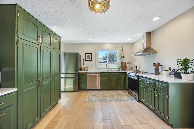 2104 Oakwood Ave, Bloomington, IL 61704 - kitchen featuring light wood-style flooring, a sink, stainless steel appliances, green cabinets, and wall chimney exhaust hood