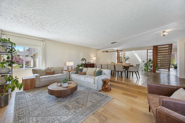 2104 Oakwood Ave, Bloomington, IL 61704 - living room with a textured ceiling, visible vents, and light wood-style flooring