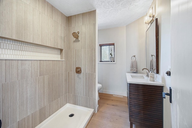 2104 Oakwood Ave, Bloomington, IL 61704 - full bath with visible vents, toilet, wood finished floors, vanity, and tiled shower