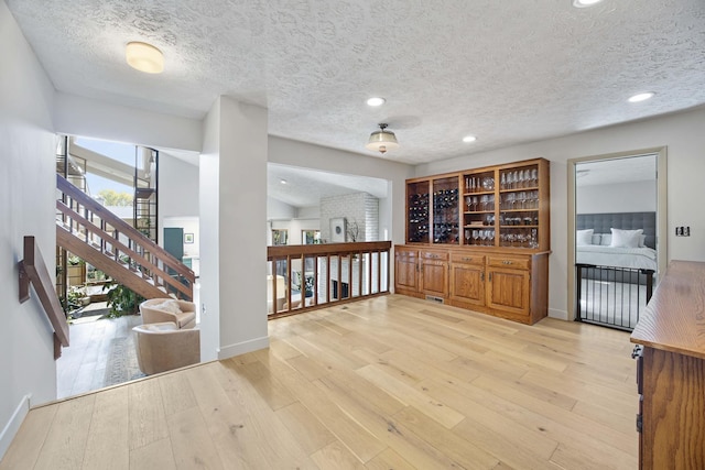 2104 Oakwood Ave, Bloomington, IL 61704 - interior space with light wood finished floors, recessed lighting, stairs, baseboards, and a textured ceiling
