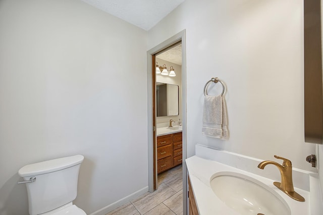 2104 Oakwood Ave, Bloomington, IL 61704 - bathroom featuring toilet, vanity, and baseboards