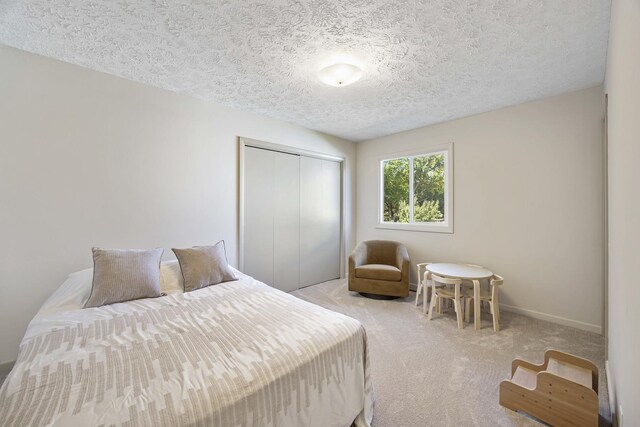 2104 Oakwood Ave, Bloomington, IL 61704 - bedroom featuring a textured ceiling, a closet, and light carpet