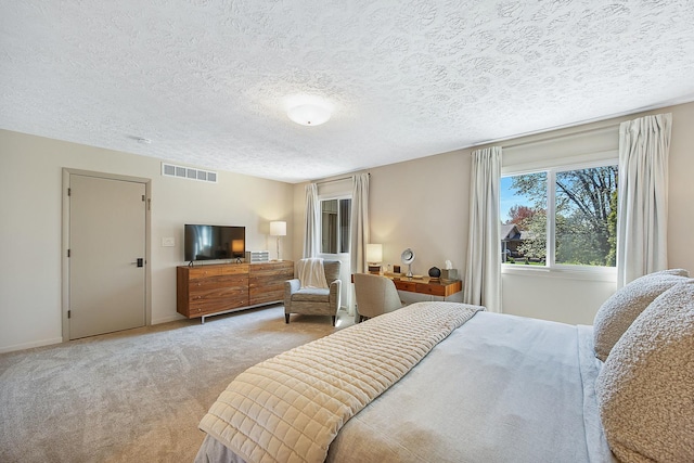 2104 Oakwood Ave, Bloomington, IL 61704 - bedroom featuring a textured ceiling, visible vents, carpet flooring, and baseboards
