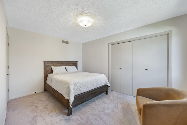2104 Oakwood Ave, Bloomington, IL 61704 - bedroom with a closet, visible vents, light colored carpet, and a textured ceiling