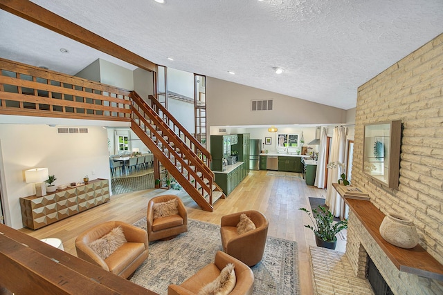 2104 Oakwood Ave, Bloomington, IL 61704 - living room featuring visible vents, stairs, and vaulted ceiling