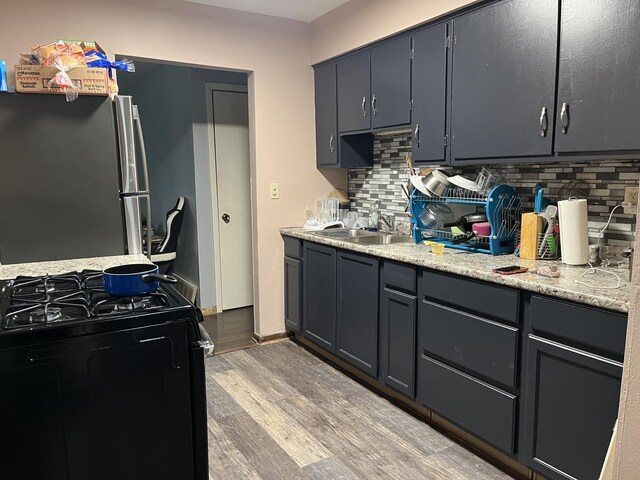 2809 Gilead Ave, Zion, IL 60099 - kitchen featuring light wood-style floors, freestanding refrigerator, backsplash, and gas stove