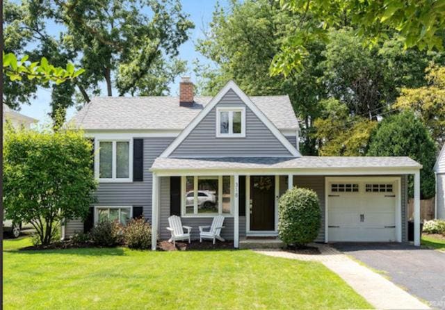 view of front of house featuring a garage, a front yard, a porch, and aphalt driveway