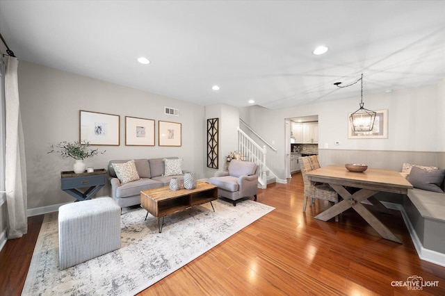 living room with visible vents, recessed lighting, wood finished floors, and stairway