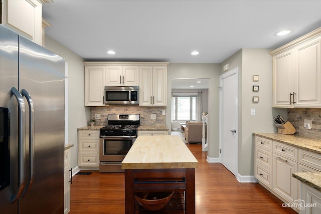 kitchen with recessed lighting, tasteful backsplash, stainless steel appliances, and dark wood-style flooring