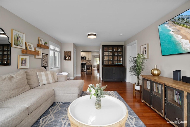 living area with baseboards and wood finished floors