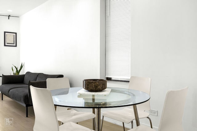 dining area with light wood-style flooring and baseboards