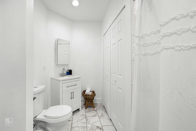 full bathroom with a closet, marble finish floor, vanity, and toilet