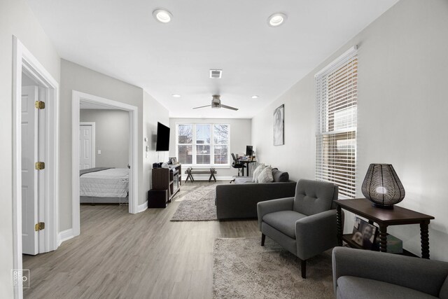 living area featuring recessed lighting, light wood finished floors, visible vents, a ceiling fan, and baseboards